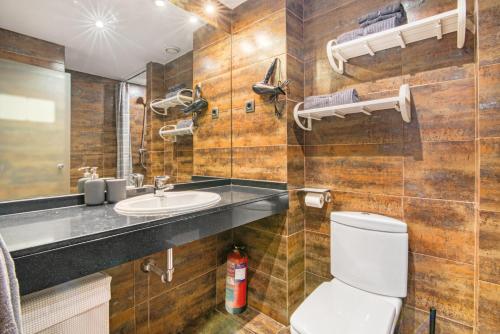 y baño con aseo y lavamanos. en Cozy Penthouse, 20 min to downtown, Alcalá Norte, en Madrid