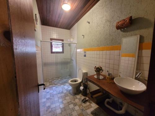 La salle de bains est pourvue d'une douche, d'un lavabo et de toilettes. dans l'établissement Sítio Vale da Cachoeira, à Pôrto Firme