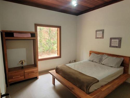 - une chambre avec un lit, un miroir et une fenêtre dans l'établissement Sítio Vale da Cachoeira, à Pôrto Firme