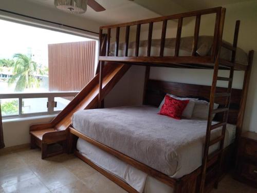 a bedroom with a bunk bed with a red pillow at PLAYA PRIVADA del desarrollo in Ixtapa