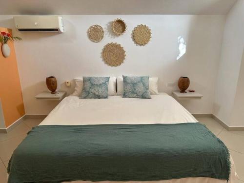 een slaapkamer met een groot wit bed met blauwe kussens bij Las Terrenas Villa- King Bed, Beaches & Dining in Las Terrenas