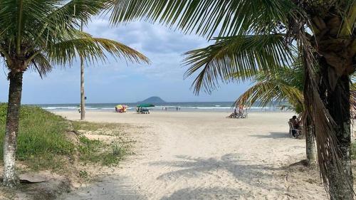 una playa de arena con palmeras y el océano en Recanto Viana en Boracéia