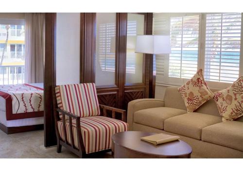 ein Wohnzimmer mit einem Sofa, einem Stuhl und einem Tisch in der Unterkunft Discover the Charm and the Sea Gardens, an Exceptional Gold Coast Studio Condo Retreat - Special Offer Now! in Pompano Beach