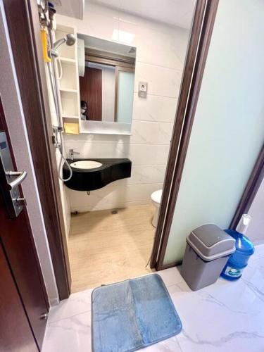 a bathroom with a sink and a toilet and a mirror at Livingatri - Skyhouse BSD next to AEON near ICE BSD in Cilandak