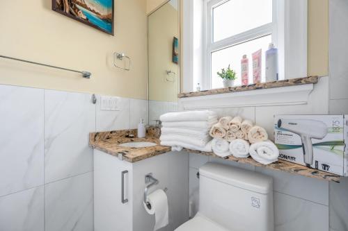 a bathroom with a toilet and a sink and a window at Three bedrooms brand new laneway house near public transit in Vancouver
