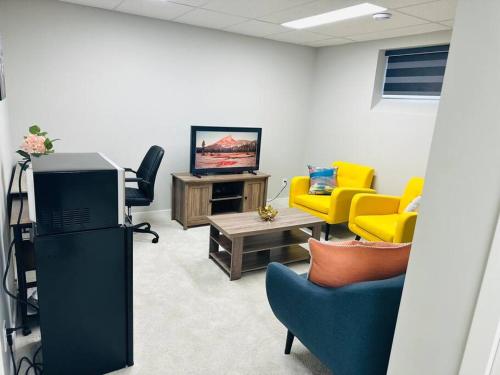 a waiting room with chairs and a tv in a room at 1 Bedroom modern basement suite with private entrance in Winnipeg