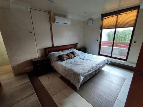 1 dormitorio con cama y ventana grande en Entre las Lomas de Chapultepec y Santa Fe, en Ciudad de México