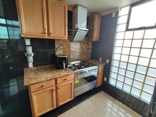 a kitchen with wooden cabinets and a stove at Santa Fe Lomas de Chapultepec in Mexico City