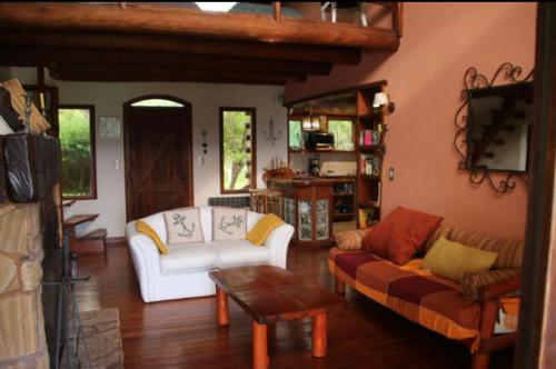 sala de estar con sofá blanco y mesa en Country Laguna El Rosario - Pinamar en Pinamar