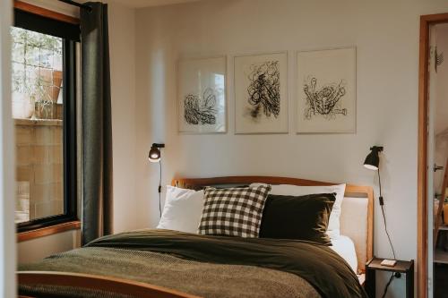 a bedroom with a bed with four drawings on the wall at Finnview House in Hobart