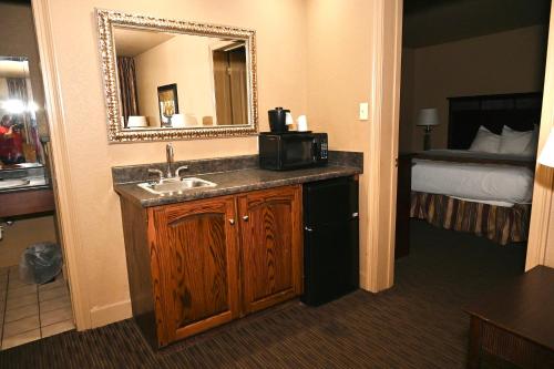 a bathroom with a sink and a mirror and a bed at Fortune Inn & Suites in Newport