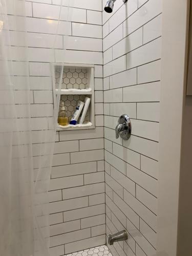 a bathroom with a shower with white tiles at Comfortable Cozy and Convenient rooms for rent in Toronto