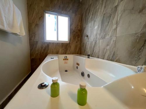 een badkamer met een bad met twee flessen erop bij AOHOM SANTUARIO HOTEL & SPA in Jiutepec