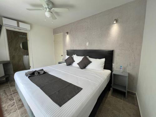 Schlafzimmer mit einem großen weißen Bett mit einem schwarzen Kopfteil in der Unterkunft AOHOM SANTUARIO HOTEL & SPA in Jiutepec