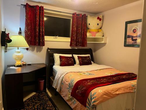 Schlafzimmer mit einem Bett, einem Tisch und einem Fenster in der Unterkunft Hamptons Rose garden family! in Calgary
