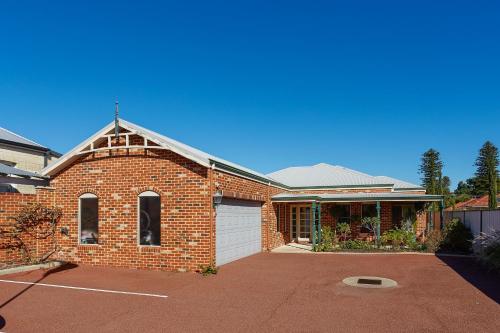 a red brick house with a white garage at Durham Lodge Bed & Breakfast in Perth