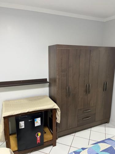 リオ・ベルデにあるResidencial Berakahの大きな木製の戸棚とその隣にテーブルがある