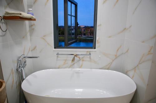 baño con lavabo blanco y ventana en Le Gia Villa 1, sang trọng, bên hồ, hướng biển, 3PN, 3 phòng tắm, Novaworld Phan Thiết cho kỳ nghỉ gia đình, en Phan Thiet