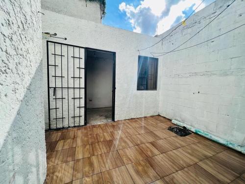 an empty room with a door and a wooden floor at La Casa del Capi in Cancún