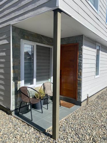 un patio con 2 sillas y una mesa en una casa en Departamento manantiales, en Punta Arenas