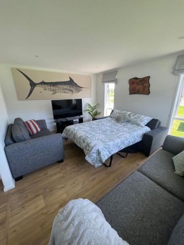 a living room with a bed and a couch at Kiwi Retreat in Kerikeri