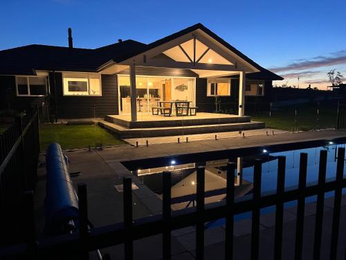 a house with a swimming pool in front of it at Kiwi Retreat in Kerikeri