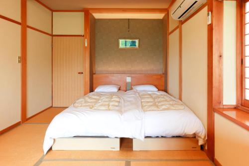 a bedroom with a bed in a small room at Jinpuso in Miyazu