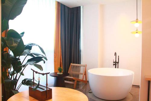 a bathroom with a tub and a table and a plant at Xishu Garden Inn - Travel Agency service - Car Rent service - English Speaking in Chengdu