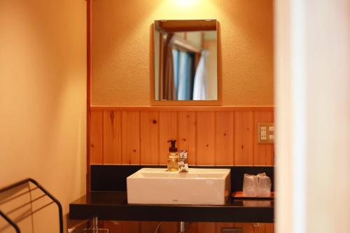 a bathroom with a white sink and a mirror at Jinpuso in Miyazu