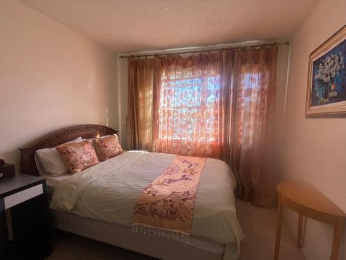 a small bedroom with a bed and a window at Hidden valley treehouse home! in Calgary