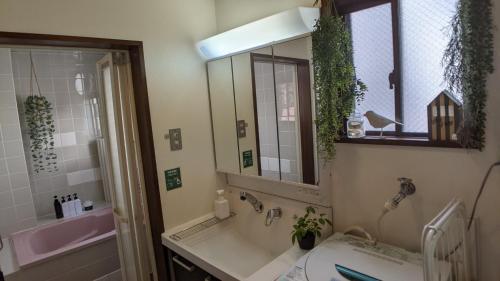 a bathroom with a sink and a tub and a mirror at Minamide Building 2-4F / Vacation STAY 6127 in Osaka