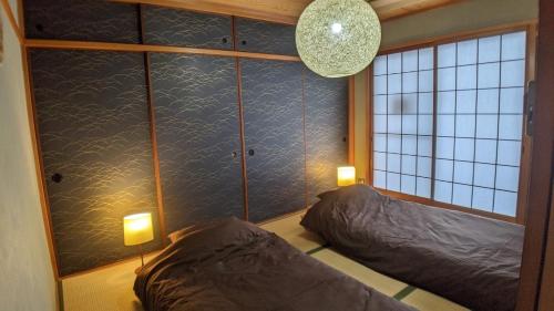 2 camas en una habitación con 2 luces en la pared en Minamide Building 2-4F / Vacation STAY 6127, en Osaka