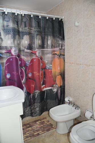 un bagno con un water e una tenda da doccia rossa a forma di scooter di Patagonia 55 a Neuquén