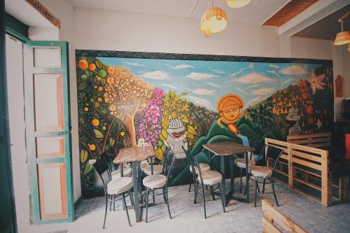 蒙圭的住宿－Hostal Casa del Frailejón - Café，餐厅墙上挂着壁画,里面摆放着凳子
