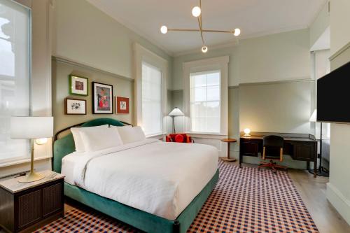a bedroom with a large bed and a piano at Trilogy Hotel Montgomery, Autograph Collection in Montgomery