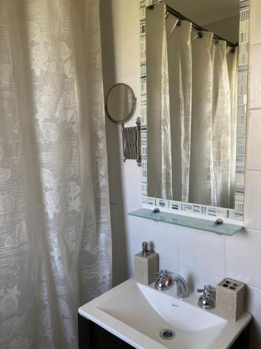 a bathroom with a sink and a mirror at C & N - Altos de la Bahía in El Calafate