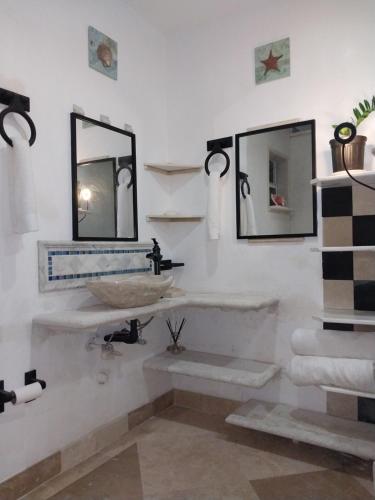 a bathroom with a sink and two mirrors at Apartment near Grace Bay Beach in Providenciales
