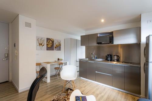 una cocina con armarios de acero inoxidable y una silla blanca en Loft nuevo, moderno, central, en Bogotá
