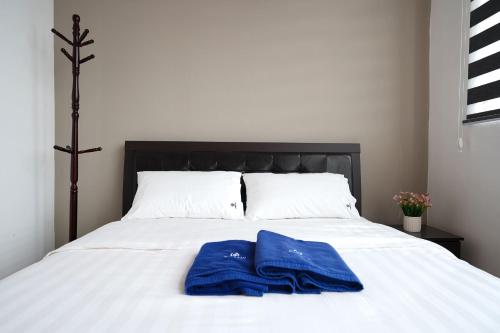 two blue towels are sitting on a white bed at ITCC Manhattan Suites by Calvin in Donggongon