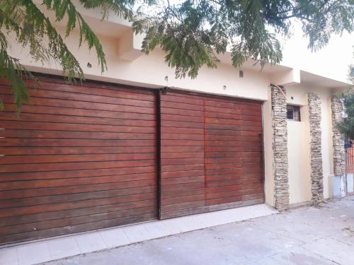 eine hölzerne Garagentür an der Seite eines Hauses in der Unterkunft El Bonsai in Santiago del Estero