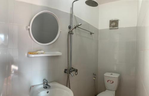 uma casa de banho com um lavatório, um espelho e um WC. em Vang Vieng Lily Backpackers Hostel em Vang Vieng