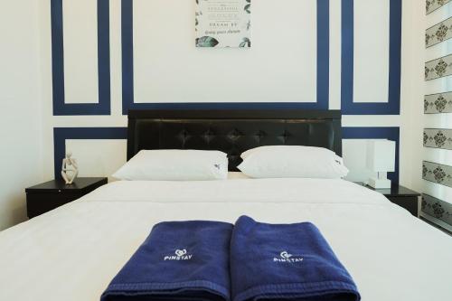 two blue towels are sitting on a white bed at ITCC Manhattan Suites by Calvin in Donggongon