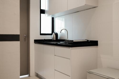 una cucina bianca con lavandino e finestra di ITCC Manhattan Suites by Pinstay Premium a Donggongon