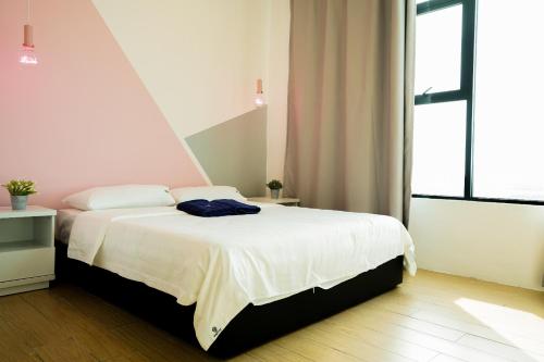 a bedroom with a white bed and a large window at ITCC Manhattan Suites by Calvin in Donggongon