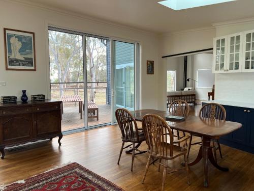 ein Esszimmer mit einem Tisch und Stühlen sowie einer Glasschiebetür in der Unterkunft Summit House Armidale - 2 or 4 Bedrooms in Armidale