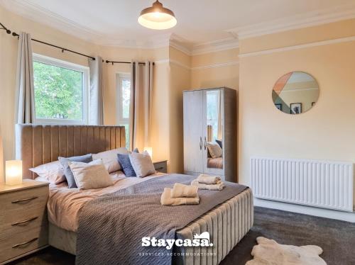 1 dormitorio con 1 cama grande y espejo en Spacious 5br Home In Prime Manchester Location, en Mánchester