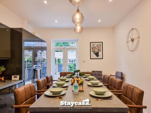 a dining room with a long table and chairs at Spacious 5BR Home in Leafy Withington - 19677 in Manchester