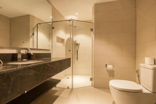W łazience znajduje się prysznic, toaleta i umywalka. w obiekcie White House Beach Resort w mieście Boracay