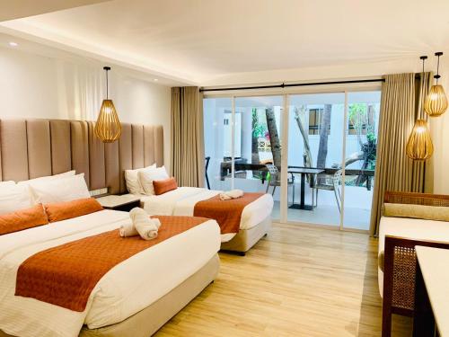 Habitación de hotel con 2 camas y balcón en White House Beach Resort, en Boracay
