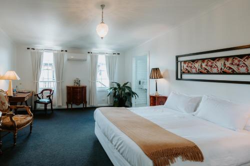 Schlafzimmer mit einem großen weißen Bett und einem Schreibtisch in der Unterkunft The Bronte Boutique Hotel in Morpeth